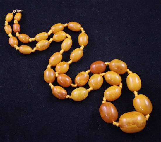 A single strand graduated oval amber bead necklace, 27in.